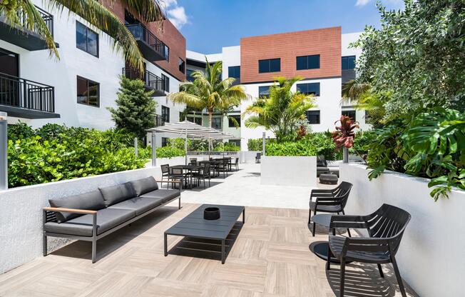 Palm-lined courtyard with outdoor seating, dining areas, and gathering spaces that bring everyday connection outdoors in Coral Springs.