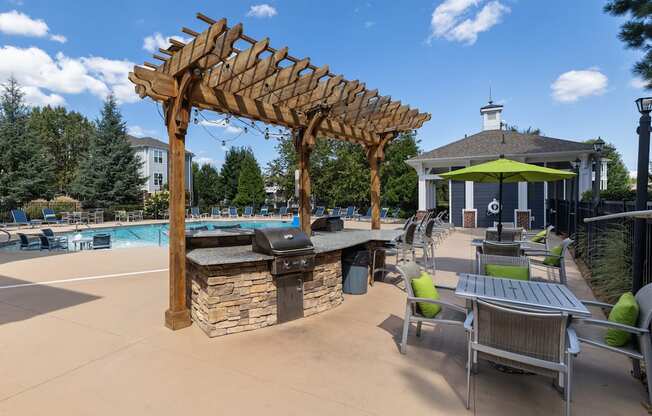 A poolside area with a grill and seating area.