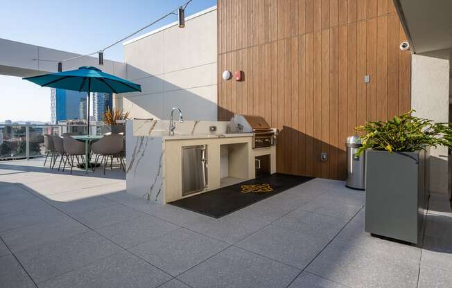 an outdoor kitchen and dining area on the roof of a building