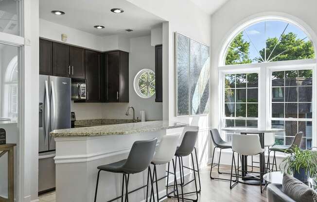 A kitchen with a bar area and a dining table.