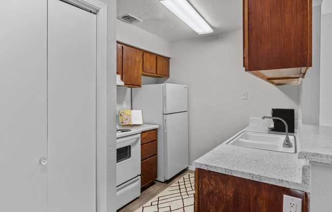 a kitchen with white appliances and a sink and a refrigerator