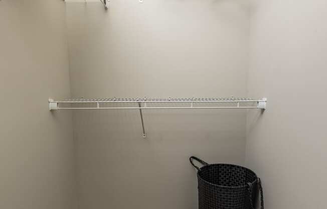 a spacious closet with shelves and a basket in the corner