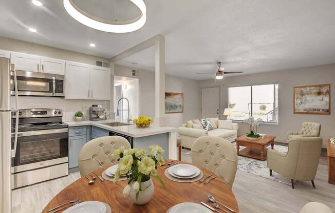 A modern kitchen with a dining table set for two.