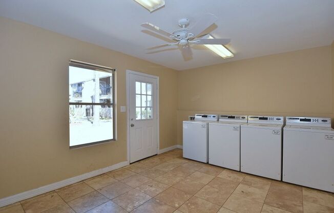 a laundry room with two washers and two dryers