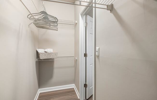 a walk in closet with a glass shower door and a hanging rack