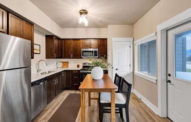 A kitchen with a table and chairs in the middle of it.