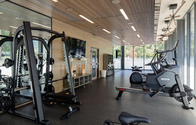 a gym with weights and a tv on the wall