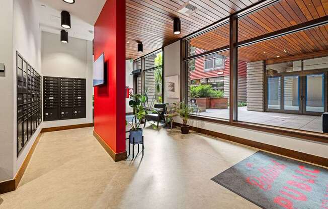 A hallway with a red wall and a black and white checkered floor.