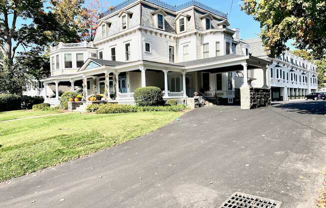 a large white house with a driveway in front of it