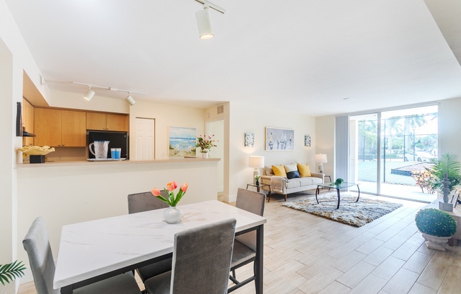 a living room and dining room with a white table and chairs