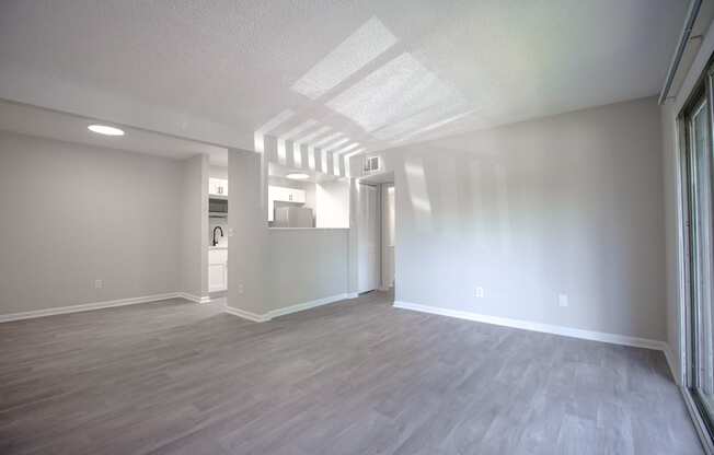 an empty living room with white walls and wood flooring