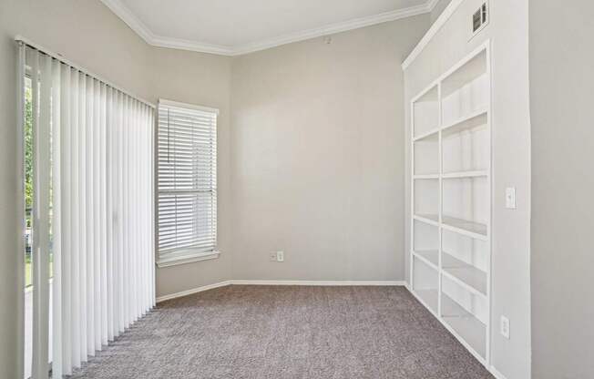 A room with a carpeted floor and a white closet.