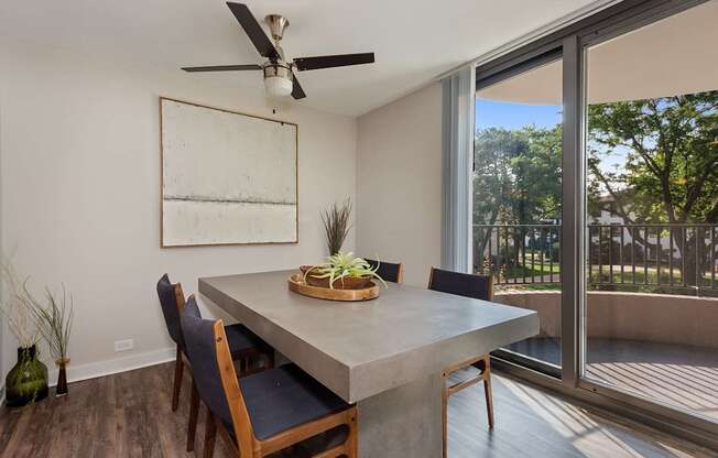A dining room with a table, chairs, and a ceiling fan.