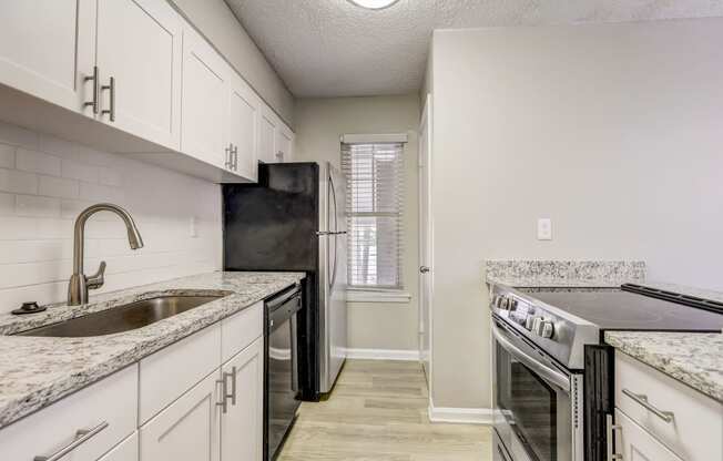 a renovated kitchen with white cabinets and a sink and a stove at Veridian