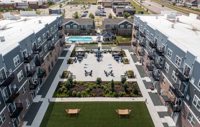 an aerial view of an apartment complex with a pool in the middle