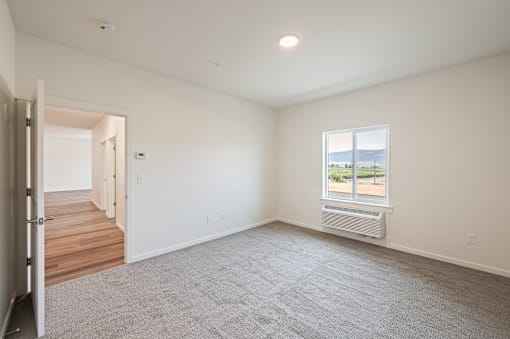 an empty living room with white walls and a window at Gateway Apartments, East Wenatchee , WA 98802