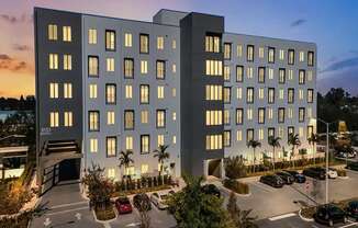 A modern building with a parking lot in front of it.