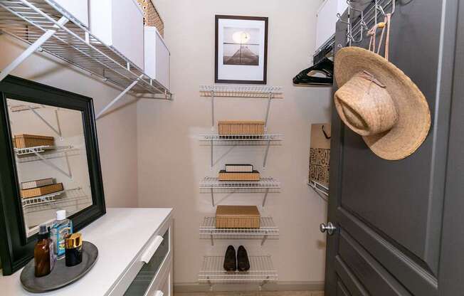 A small pantry with a hat hanging on the door.