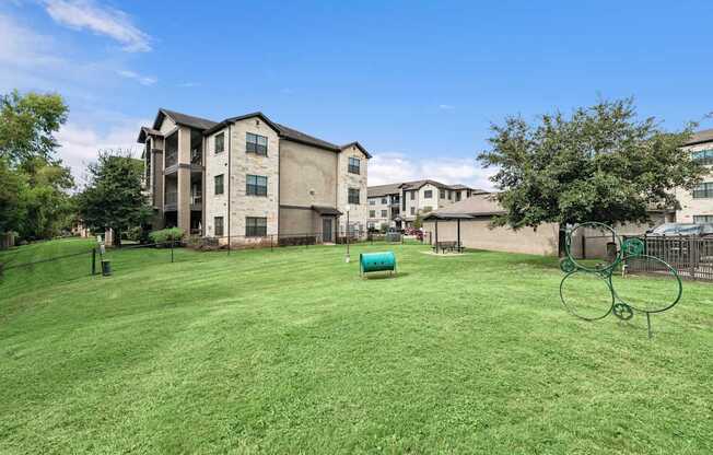 A large grassy area in front of apartment buildings.