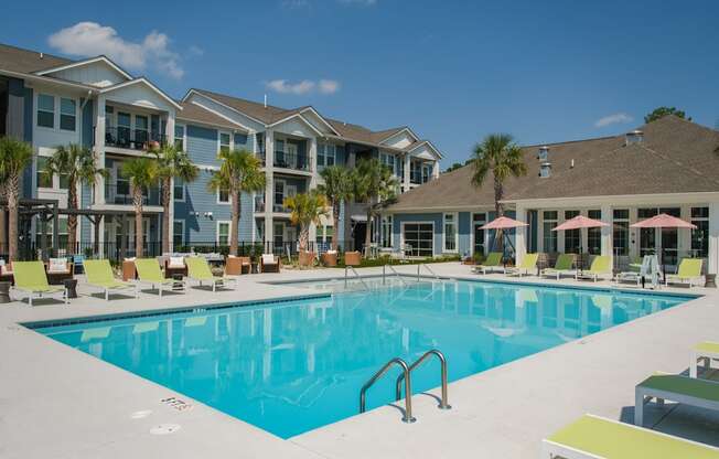 A large swimming pool in front of a building with a sunny day.