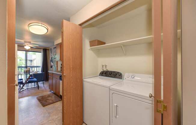 In Unit Washer and Dryer, Wood Cabinets, Shelves and View of Dining Room