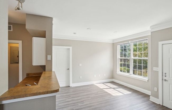 an empty kitchen and living room with a large window