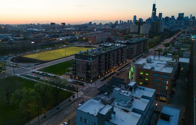 A cityscape at sunset with a prominent building in the background.