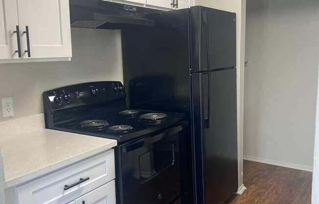 a kitchen with black appliances and white cabinets