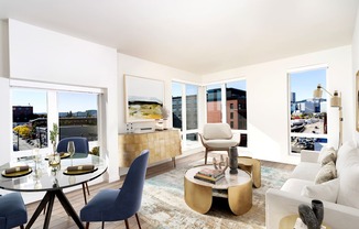 A modern living room with a glass table and blue chairs.