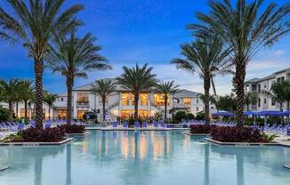 a large pool with a bunch of palm trees in front of a building  at Palm Bay Club, Jacksonville