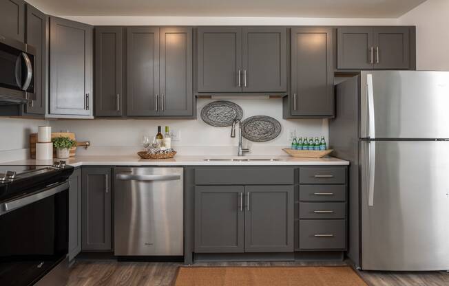 a kitchen with stainless steel appliances and gray cabinets