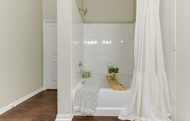 a white bathroom with a tub and a shower curtain