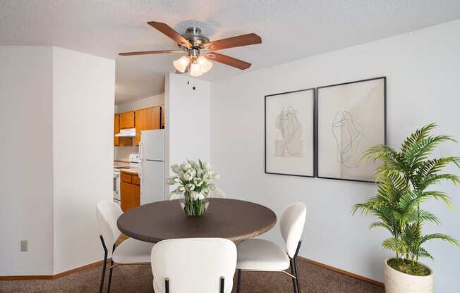 a dining room with a table and chairs and a ceiling fan. Fargo, ND Westview Towers Apartments