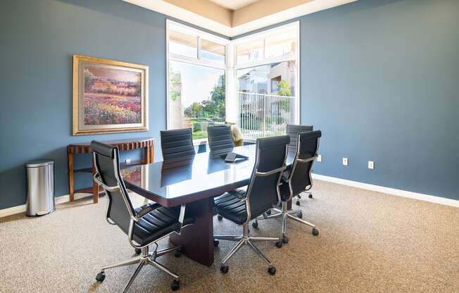 A conference room with a large table and chairs.