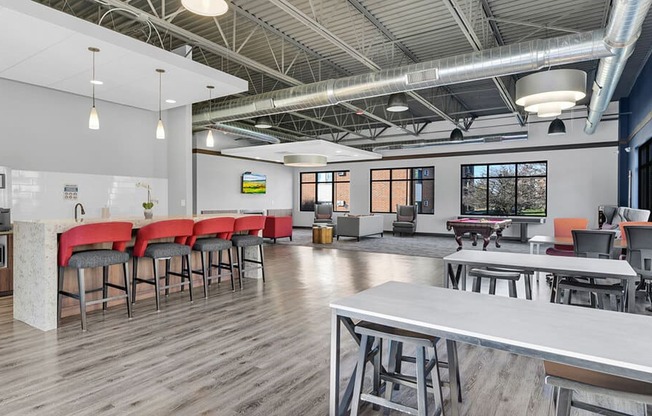 a communal area with tables and chairs and a ping pong table