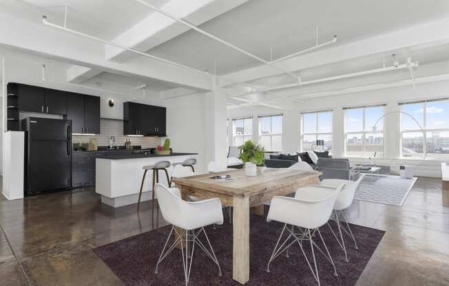 a living area with a dining table and chairs and a kitchen