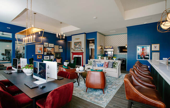 a living room with blue walls and a desk with a computer