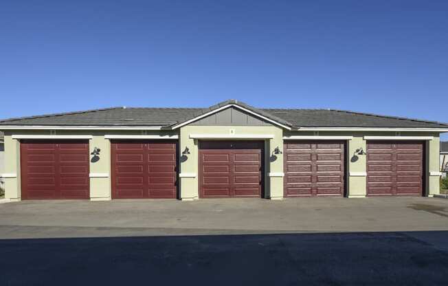 a garage with red doors in front of a house