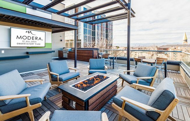 Rooftop social lounge with fire pit and wall mounted TV