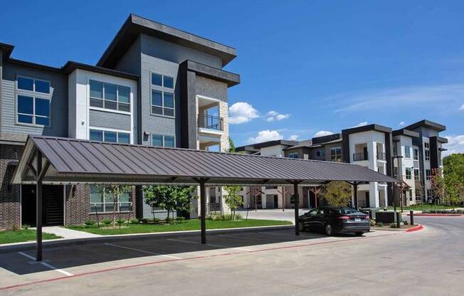 a large building with a car parked in front of it at Hunters Creek Apartments, Denton, 76210