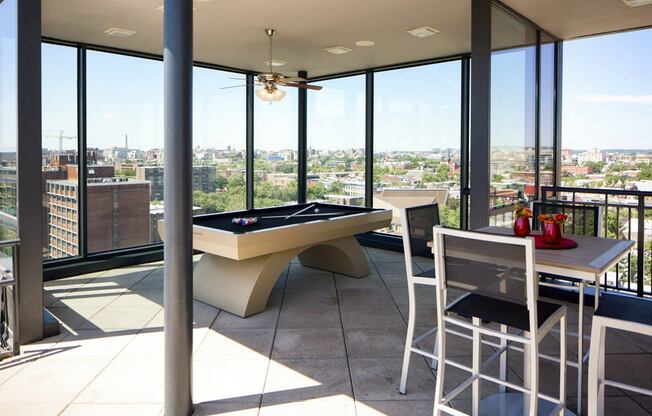 a living room with a pool table and a view of the city