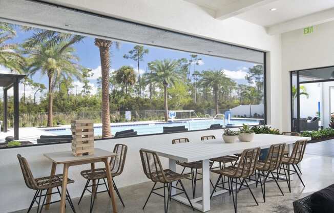 a large white table and chairs sit in front of a large window with a view of a at Odyssey, Fort Myers, FL, 33905