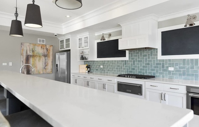 A kitchen with white cabinets and a white island.