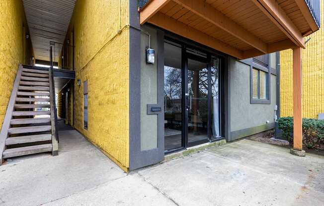 A yellow building with a wooden roof and a glass door.