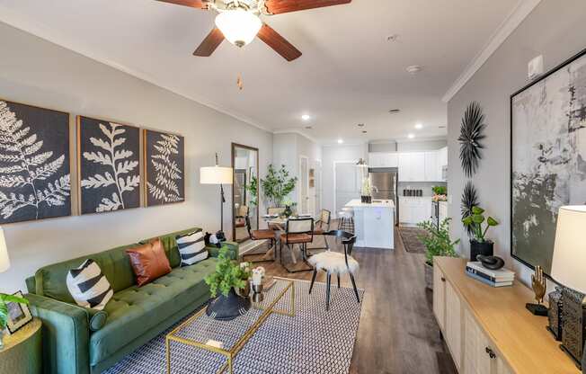 a living room with a green couch and a ceiling fan