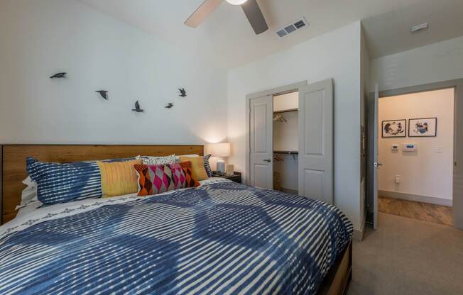 A bedroom with a bed and a ceiling fan.