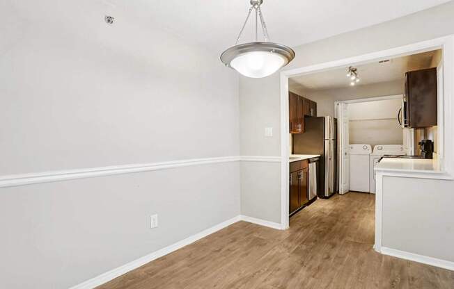 A kitchen area with a refrigerator, oven, and cabinets.