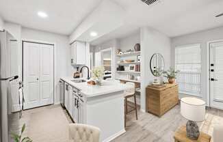 a kitchen and living room with white walls and a wooden floor at Carmel at Deerfield, San Antonio, TX