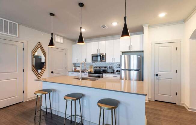 A kitchen with a white counter and bar stools.