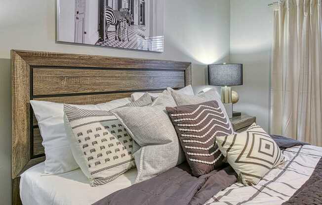 A bed with a wooden headboard and a painting of a zebra above it.